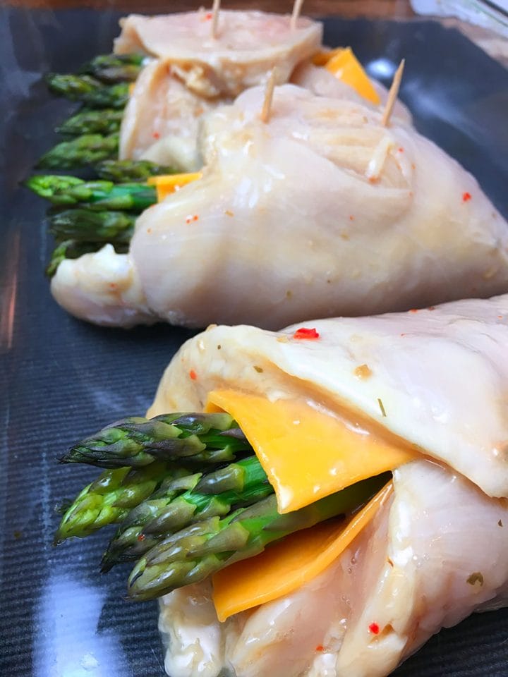 Stuffed chicken breast with asparagus and cheddar ready to go into the oven.