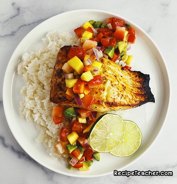 Air fryer citrus garlic salmon served with white rice and mango salad.