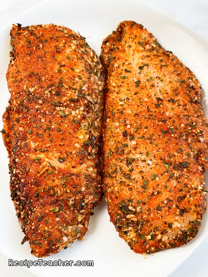 Seasoned chicken breasts ready to be cooked in a George Foreman Grill.
