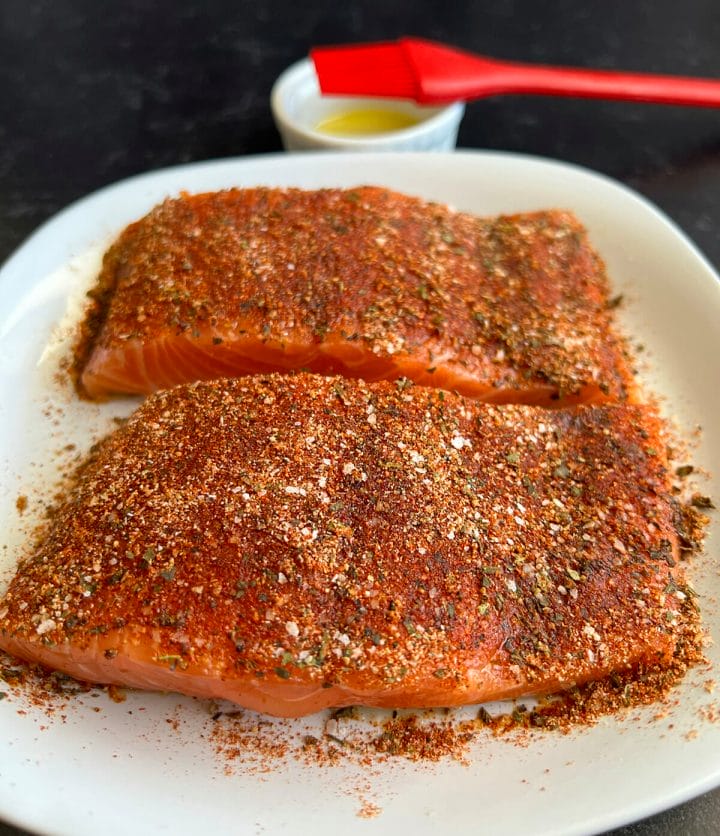 Vibrant and bold seasonings are applied to salmon filets to be made in an air fryer.