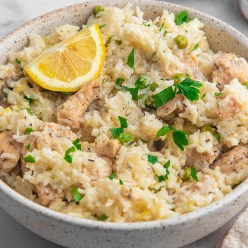 A bowl of creamy lemon chicken and white rice made in an Instant Pot pressure cooker.