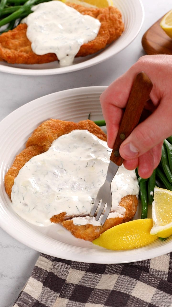 Serving pork schnitzel with a creamy dill sauce.