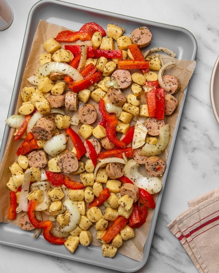Sheet pan gnocchi with sausage and peppers ready to go into the oven.