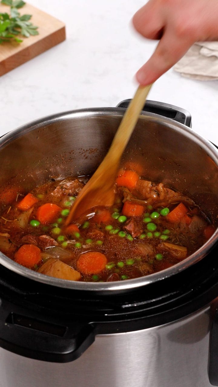 Stirring beef stew that's been cooked in an Instant Pot.