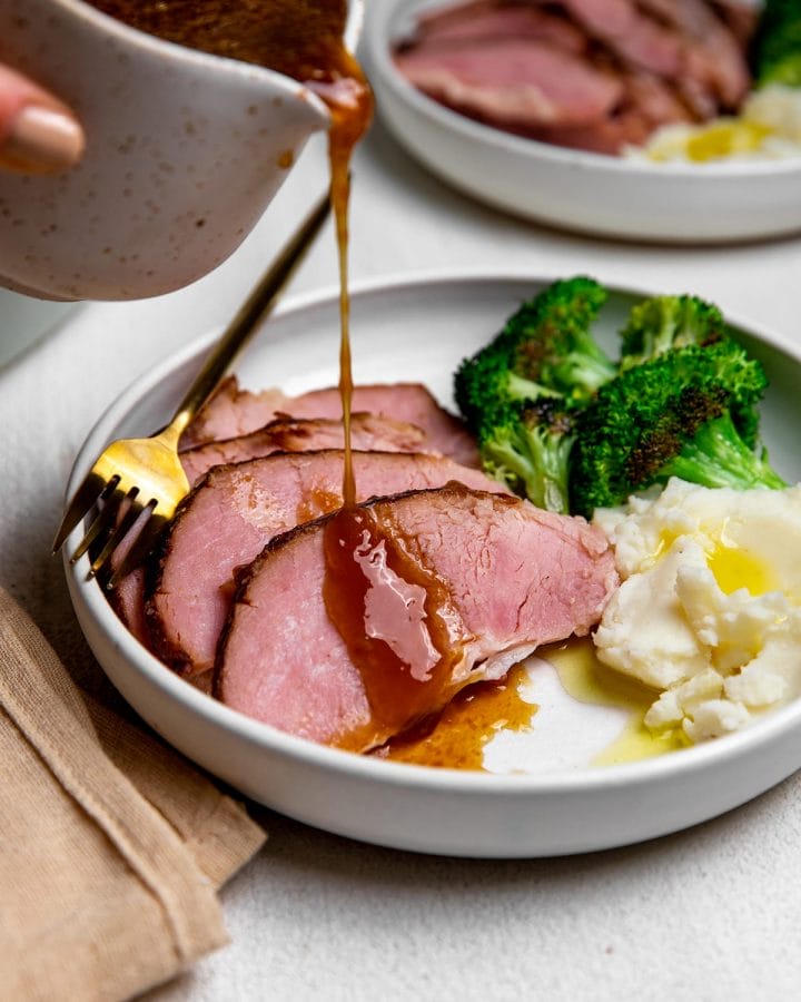 Serving baked ham with a maple and brown sugar glaze, mashed potatoes and broccoli.